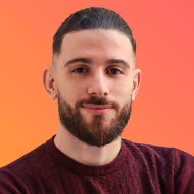 Portrait of Arezki Amiri, a young man with a well-groomed beard, wearing a burgundy sweater, on an orange gradient background.